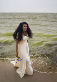 Portrait of young woman standing on beach