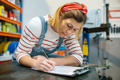 Woman checking stock products of mechanic garage