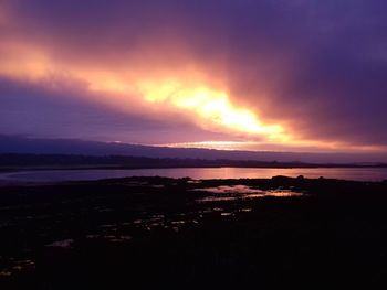 Scenic view of sea against dramatic sky during sunset