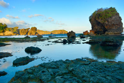 Rocks on sea shore against sky
