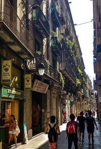 People walking on street amidst buildings in city