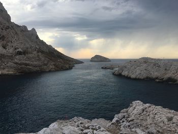 Scenic view of sea and mountains against sky