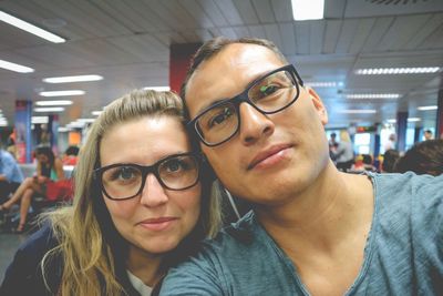 Close-up portrait of couple sitting at illuminated airport
