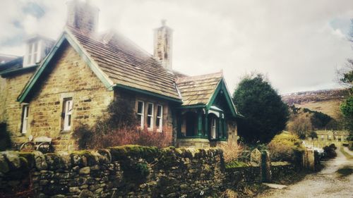 Old houses and buildings in city against sky