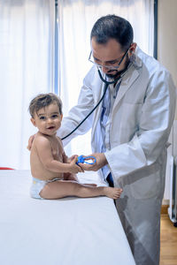 Doctor observing a one-year-old baby