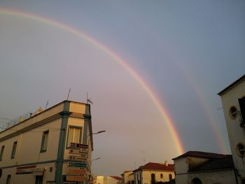 Low angle view of rainbow over buildings