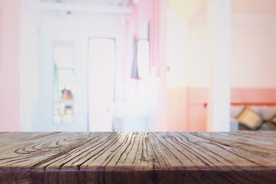 Close-up of wooden table against wall at home