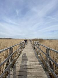 Rear view of man walking on boardwalk