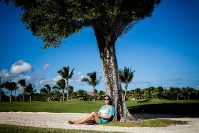 Full length of woman sitting on land against sky