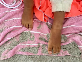 Low section of person relaxing on beach towel