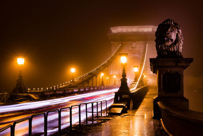 Statue of illuminated bridge at night