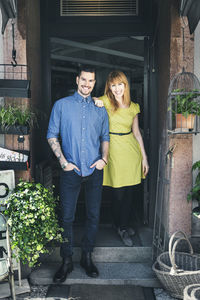 Portrait of confident colleagues standing at store doorway