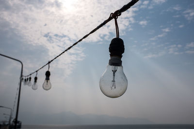 Low angle view of hanging over sea against sky