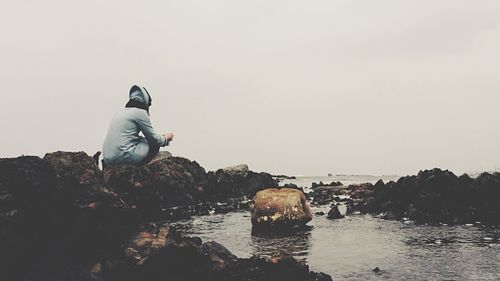 Man in sea against clear sky