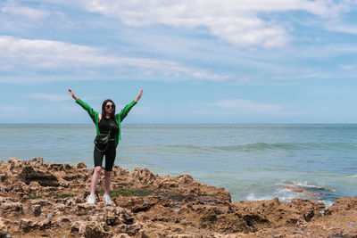 Young girl on the rocky shore of the northern sea.