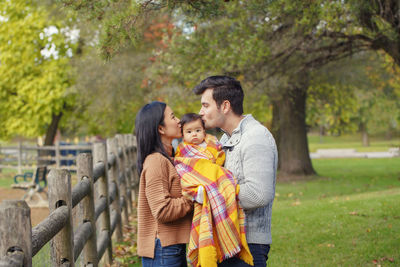 Couple standing with baby at park