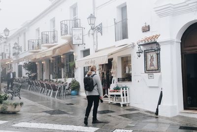 Man standing on street against buildings in city