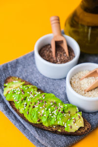 Ingredients for healthy avocado toast. ripe hass avocado, wholegrain bread, sesame flax seeds oil. 