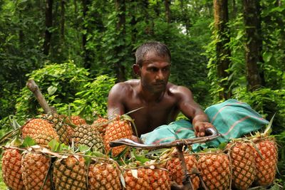 Portrait of woman picking fruits in forest