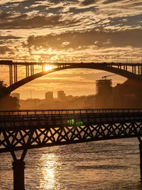 Sunset in porto portugal on the douro river looking at the ponte da arrabida bridge