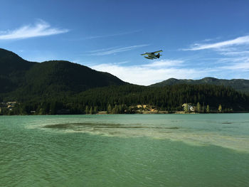 Airplane flying over sea against sky