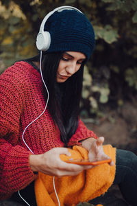 Young woman listening music with her headphones in the forest