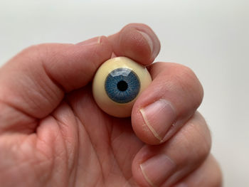 Hand holding blue movie-prop eyeball