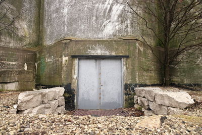 Spooky and creepy gray steel double door leading into damp concrete building. high quality photo