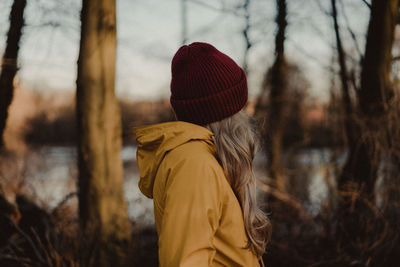 Side view of woman standing in forest