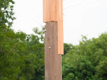 Low angle view of wooden post on field