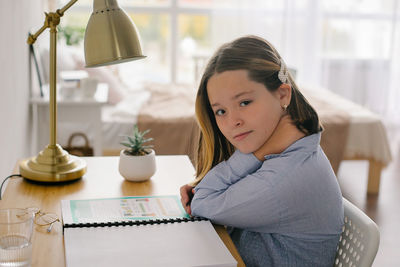 Side view of young woman sitting on table