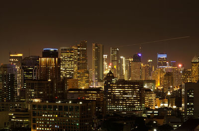 Illuminated cityscape against sky at night