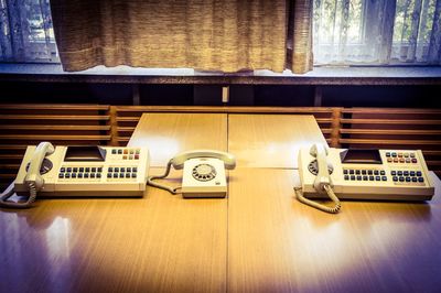 High angle view of landline phones on wooden table