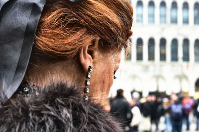 Close-up portrait of woman looking away in city