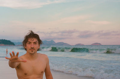 Portrait of young man standing at copacabana beach in rio de janeiro 