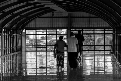 Rear view of people walking in corridor