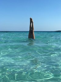 Low section of man in swimming pool against sea