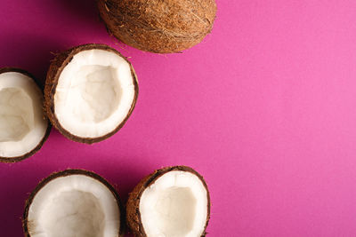 Coconut fruits on pink purple vibrant plain background, abstract food tropical concept