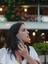 Candid portrait of young woman talking on the phone in city