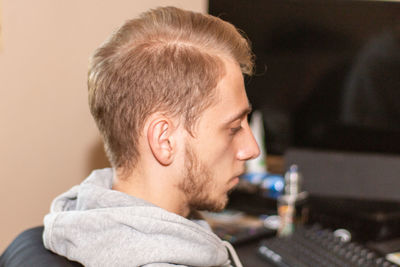 Side view of young man looking away at home