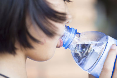 Close-up of a woman drinking from water bottle