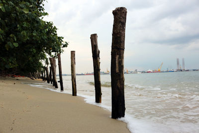 Pier on sea against cloudy sky