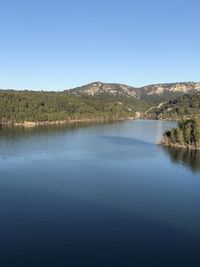 Scenic view of lake against clear blue sky