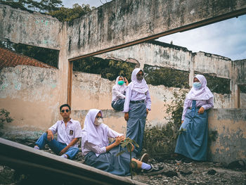 People sitting on retaining wall