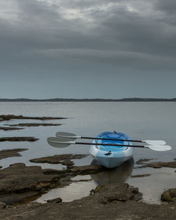 Boat moored in lake against sky