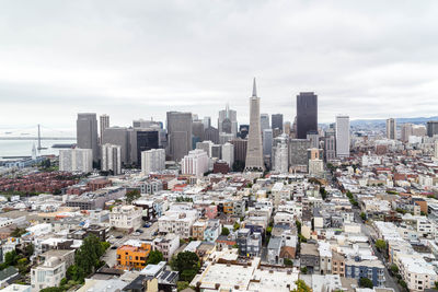 Aerial view of buildings in city against sky