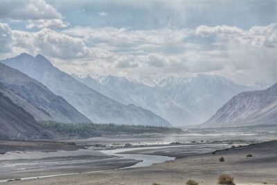 Scenic view of land and mountains against sky