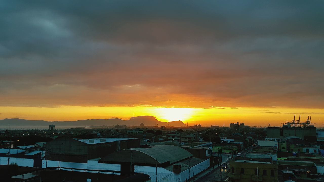 sunset, building exterior, orange color, sky, architecture, cloud - sky, built structure, sun, city, high angle view, house, cityscape, scenics, residential structure, dramatic sky, beauty in nature, residential building, residential district, cloudy, town