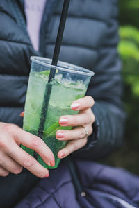 Midsection of woman holding juice in glass