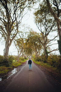 Rear view of man walking on road